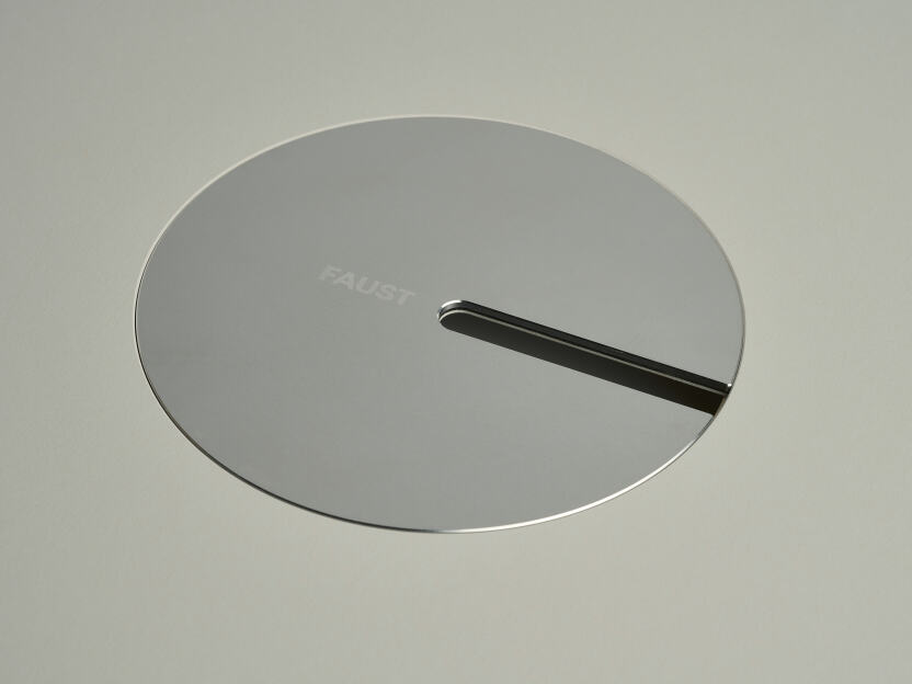 Eine eloxierte Aluminium-Ovalabdeckung für Kabel von Daniel Lorch. Sie sitzt in der Aussparung der Tischplatte und organisiert effektiv Kabel, indem sie sie vor Abrieb schützt.