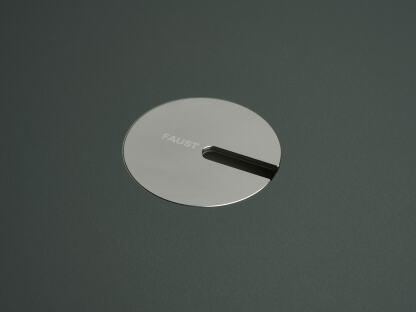 Eine eloxierte Aluminium-Rundabdeckung für Kabel von Daniel Lorch. Sie sitzt in der Aussparung der Tischplatte und organisiert effektiv Kabel, indem sie sie vor Abrieb schützt.