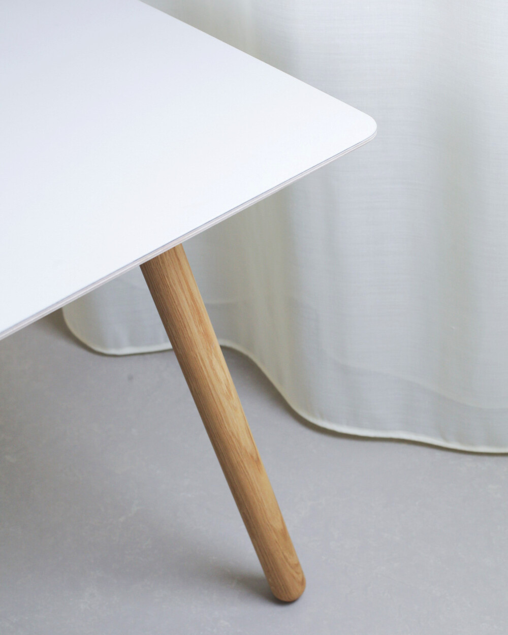 Light grey linoleum tabletop with MT2 oak table frame, detailed view of the table edge and one table leg.