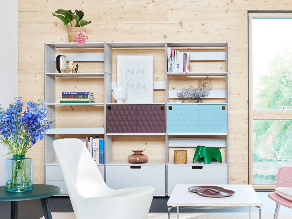Plus Minus shelf by Faust made of linoleum and MDF, decorated with books and objects in front of a light wood wall.