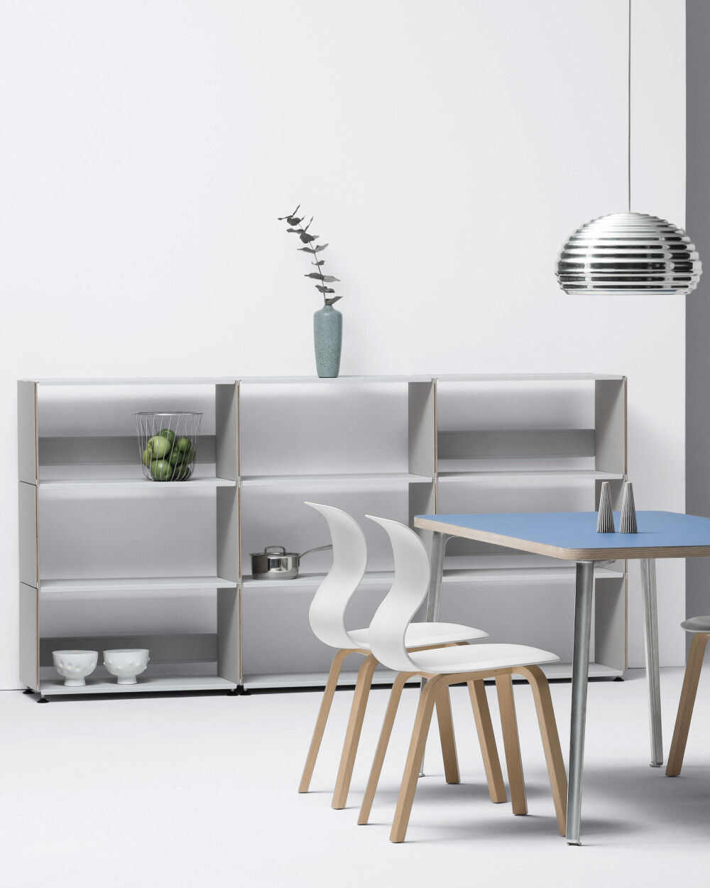 Plus Minus shelf by Faust in light grey with linoleum surface, combined with a blue table and chairs in the dining room.