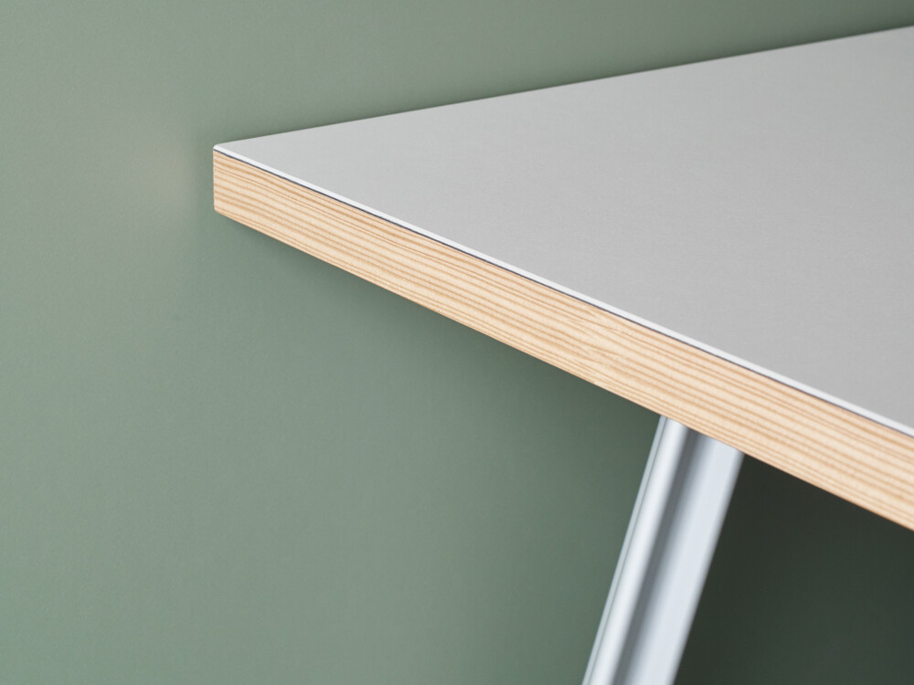 Corner detail of a rectangular wooden tabletop lined in light linoleum and mounted on a Beam aluminium table frame by Daniel Lorch for Faust Linoleum