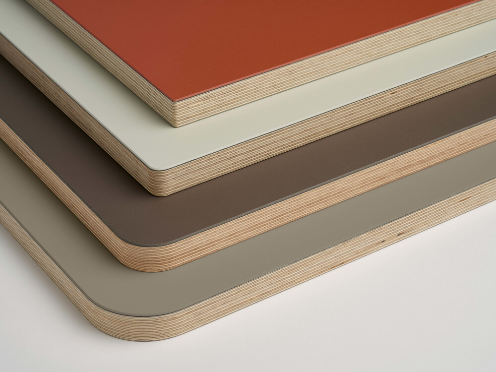 Gestapelte Linoleum-Tischplatten von Faust in den Farben in den Farben Brick, Vapour, Mauve,Taupe mit unterschiedlichen Eckradien.