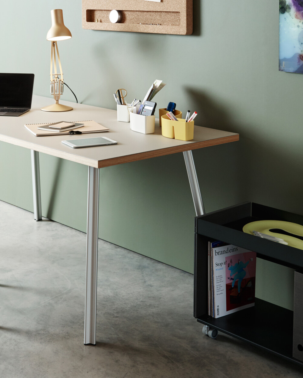 Beam desk with light-colored top in a cozy setting, furnished as a home office with chair, lamp, and storage space.