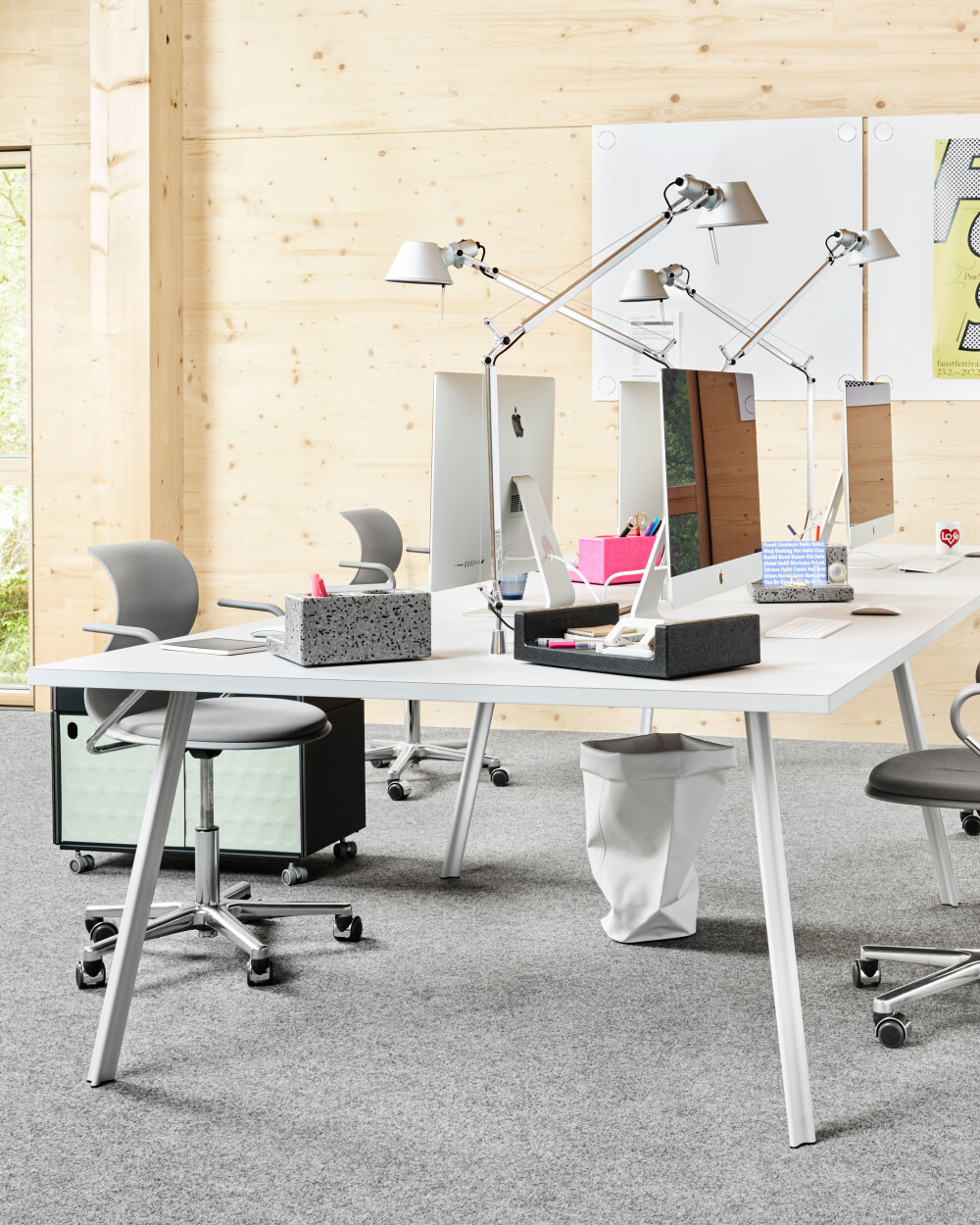 Beam desks with light gray linoleum in a bright office, used as modern workstations with monitors and storage space.