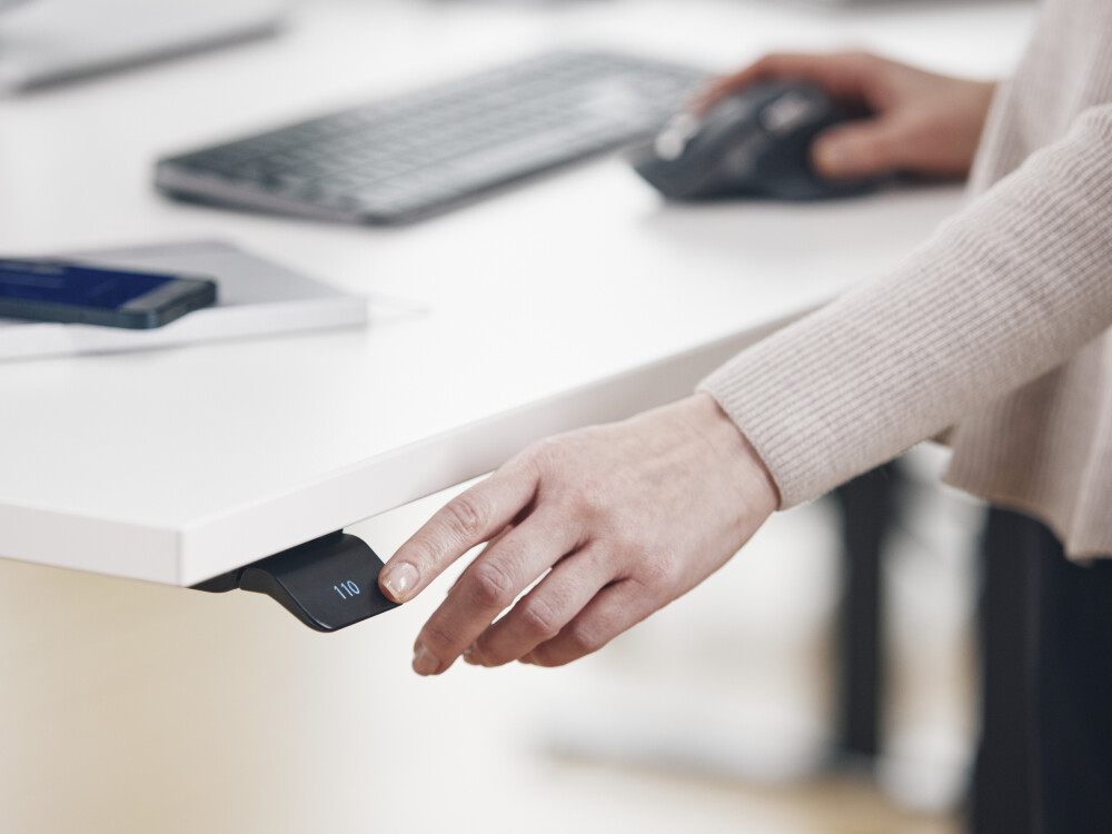 Weißer ATS Schreibtisch mit integriertem Standard Bediendisplay zur Höhenverstellung, gezeigt in moderner Büroumgebung.