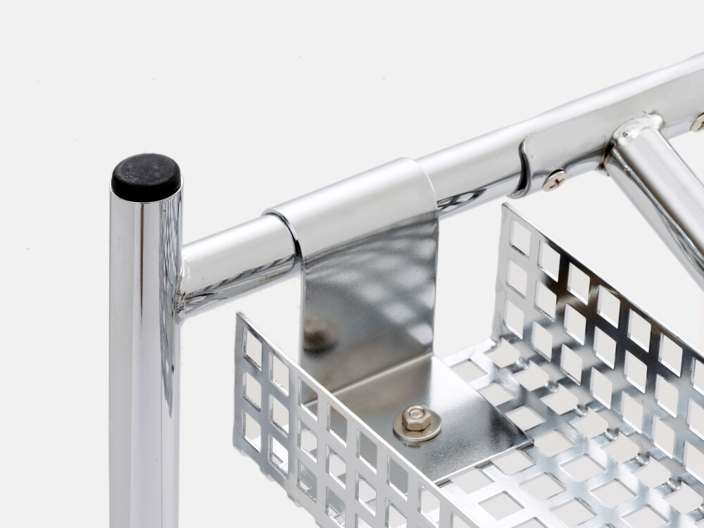 Detailed view of the metal bracket and fastening of the cable channel to the E2 table frame for secure cable routing under the tabletop.