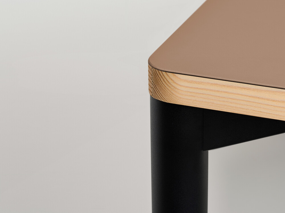Detailed view of the Outline table top by Faust with linoleum surface in warm beige and larch wood edge.