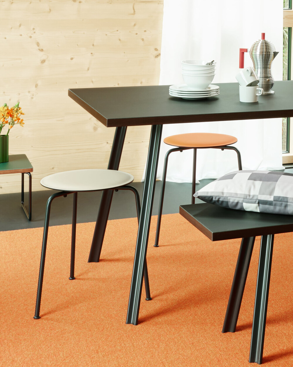 RAVIOLI stool with linoleum seats in warm colours at a dining table in a modern setting.