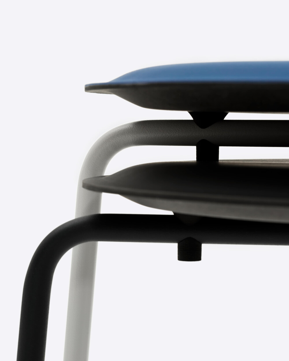 Stacked RAVIOLI stools by Faust with linoleum seats and steel frames against a white background.